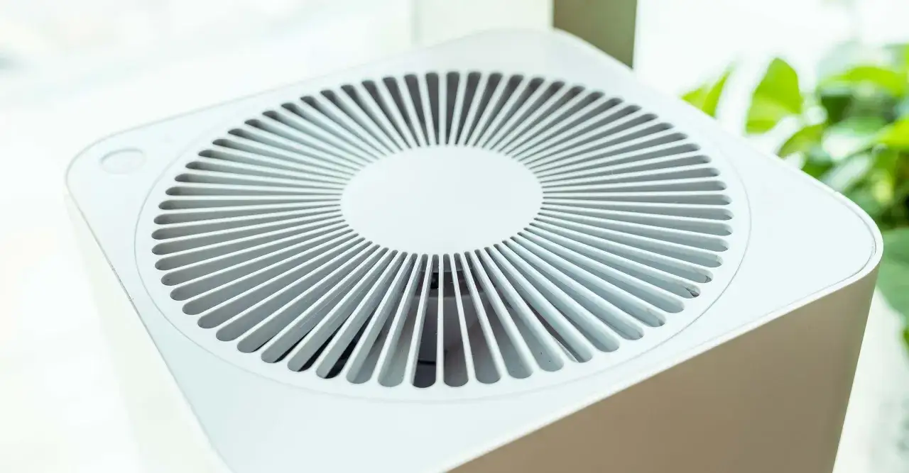 Purificador de aire blanco con rejilla circular. Considera las contraindicaciones del purificador de aire para un uso seguro y eficaz.