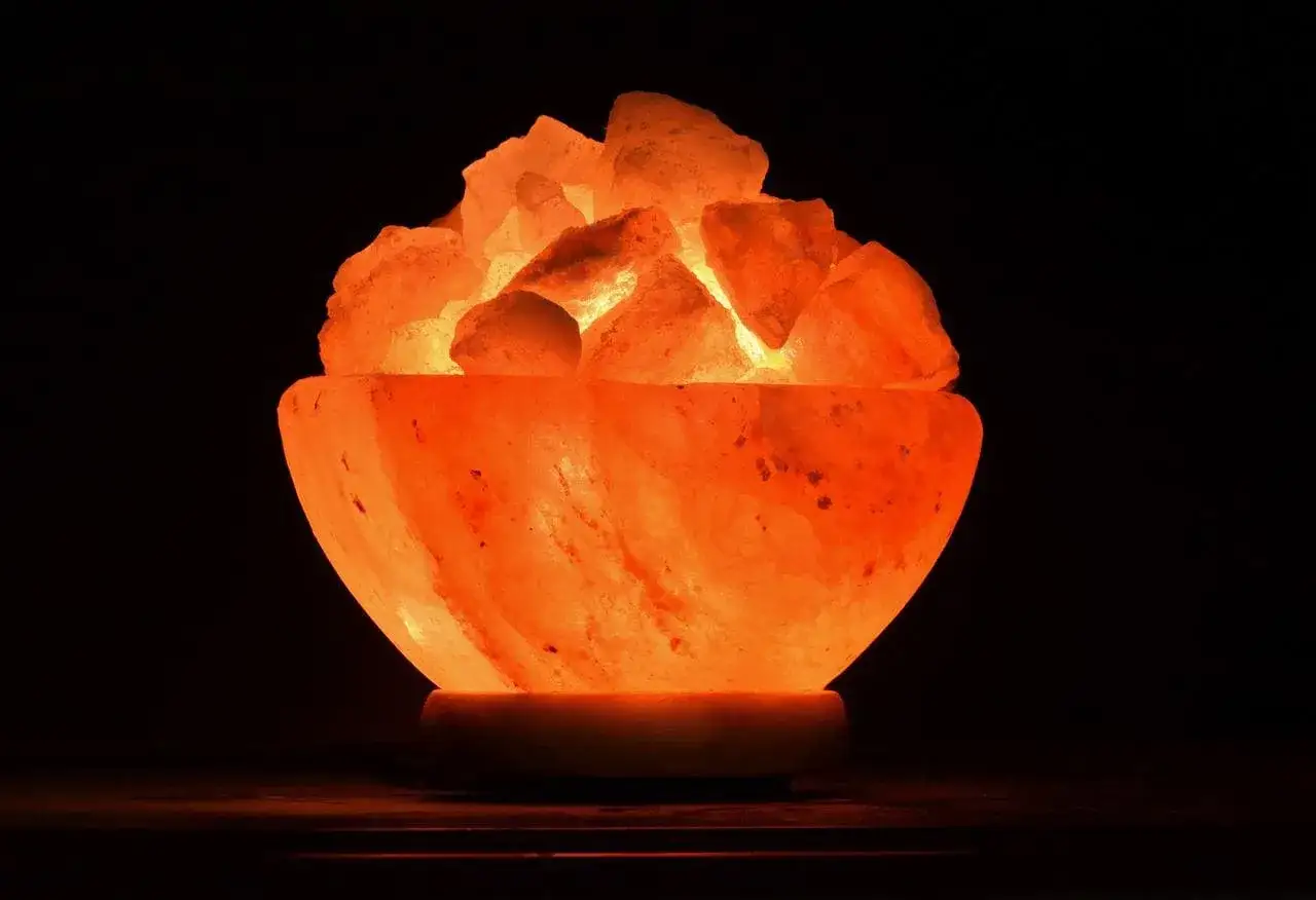 L&aacute;mpara de sal con trozos de sal rosa iluminados desde dentro, creando un ambiente c&aacute;lido. Su dise&ntilde;o en forma de cuenco es ideal para controlar la humedad.